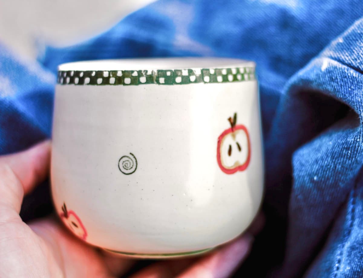 Apple motif cup with checkered rim